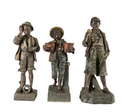 trois statues représentant des hommes, toutes coiffées d'un chapeau