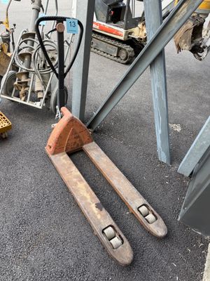 un chariot élévateur posé au sol à côté d'un tas d'autres engins
