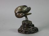 statue of a bird perched on a rock with a bird on it ' s head