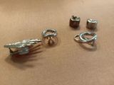 three pairs of silver earrings on a table