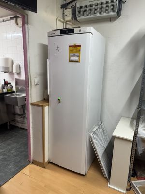 un réfrigérateur qui se trouve dans une pièce près d'une fenêtre