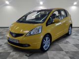 La voiture jaune est garée dans le garage, sur le sol à damier.