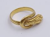 an image of a gold snake ring on a white surface