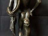 a bronze statue of a man holding a dog on a black background