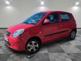 the small red car is parked in a room with a checkered floor