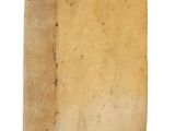 un vieux livre à la couverture brune posé sur une surface blanche