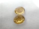 a pair of yellow sapphires sitting on top of a white surface