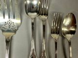 a lot of silver spoons and forks on the table
