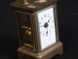 a small clock that is sitting on a black surface