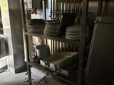 many plates and pans stacked on a shelf in the kitchen
