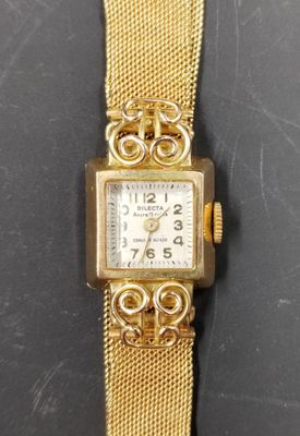 gros plan d'une montre en or sur une surface noire
