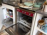 un lave-vaisselle au milieu d'une cuisine, avec de la vaisselle à l'intérieur