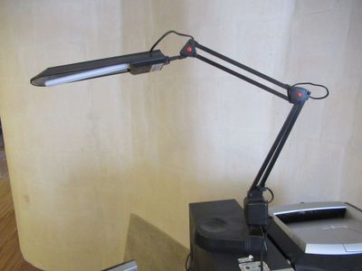 une lampe posée sur un bureau, à côté d'une imprimante