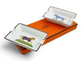 deux assiettes en porcelaine ornées de chevaux, posées sur une boîte orange
