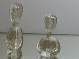 two clear glass bottles sitting on a glass table