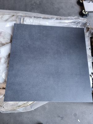 une personne debout à côté d'une feuille de papier posée sur une table