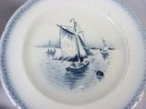 a blue and white plate with a picture of a sailboat on it