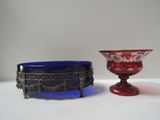 two red and blue glass bowls sitting next to each other on a table