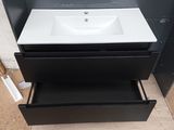 a white sink sitting on top of a black cabinet