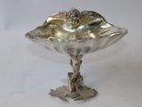 a silver plate with a flower on it on a table