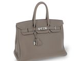 a grey leather handbag on a white background