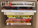 many books in a box that are stacked on top of each other