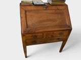 un petit bureau en bois sur lequel est posée une horloge