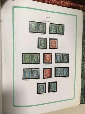 an open book with a bunch of stamps on it sitting on a table