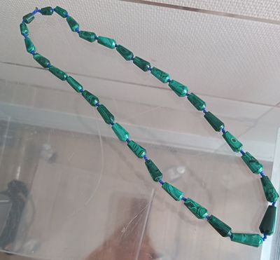 a green beaded necklace hanging from the ceiling of a room