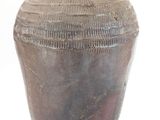 un vase brun posé sur une surface blanche