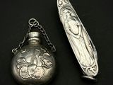 une cuillère en argent et une montre de poche en argent posées sur une surface noire