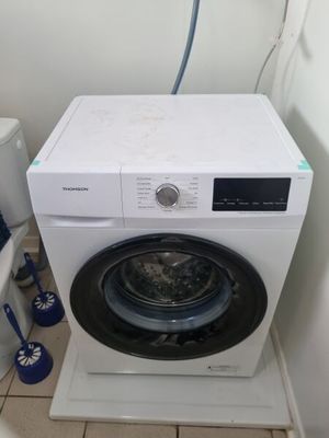 une machine à laver et des toilettes dans une petite pièce