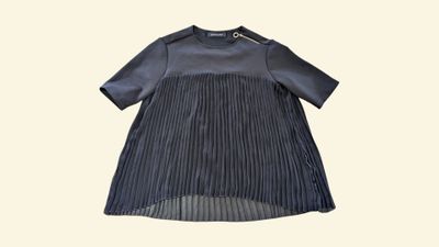 a black dress with pleas on a white background