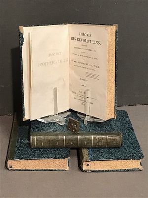 un livre ouvert posé au sommet d'une pile de livres