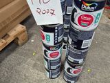 Plusieurs pots de peinture sont empilés les uns sur les autres dans un entrepôt