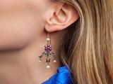 the woman is wearing a blue shirt and a pair of earrings