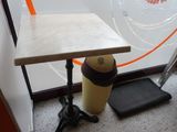 a small table with a bottle on it next to a ladder
