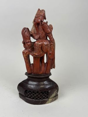 an old wooden statue of a man and woman on a horse