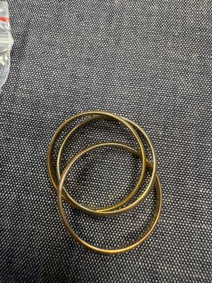 un gros plan sur une paire de bagues en or posées sur un tissu