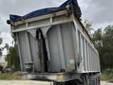un camion-benne avec une bâche à l'arrière