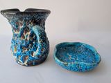 a blue and black vase and a bowl on a table