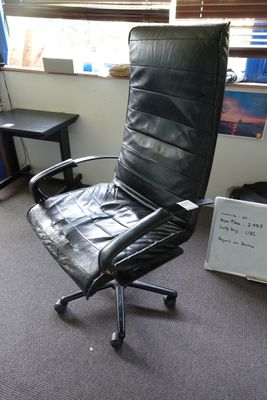 une chaise de bureau en cuir noir dans un coin de la pièce