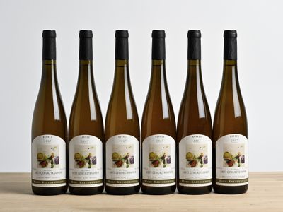 six bouteilles de vin sont alignées sur une table en bois