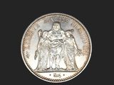 an image of a silver coin with a picture of a woman and a man on it