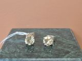 une paire de boucles d'oreilles en diamant posée sur un bloc de marbre