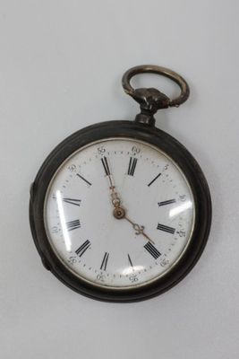 a black pocket watch with roman numerals on the face