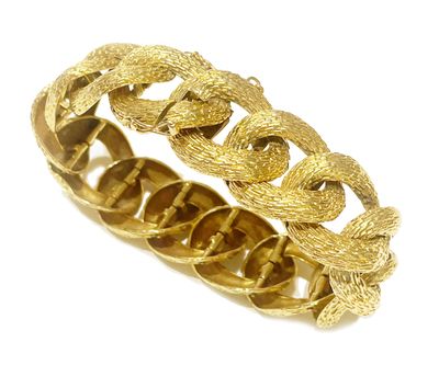 a close up of a gold bracelet on a white background