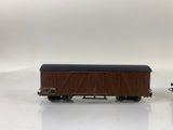 two toy trains on a white surface one is brown and the other is black