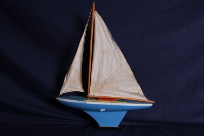 un petit voilier qui flotte sur une étendue bleue