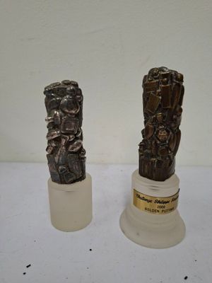two statues of a man and a woman sitting on a pedestal